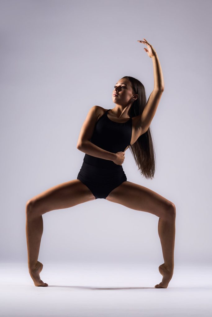 Photo of dancer on her toes and hugging waist